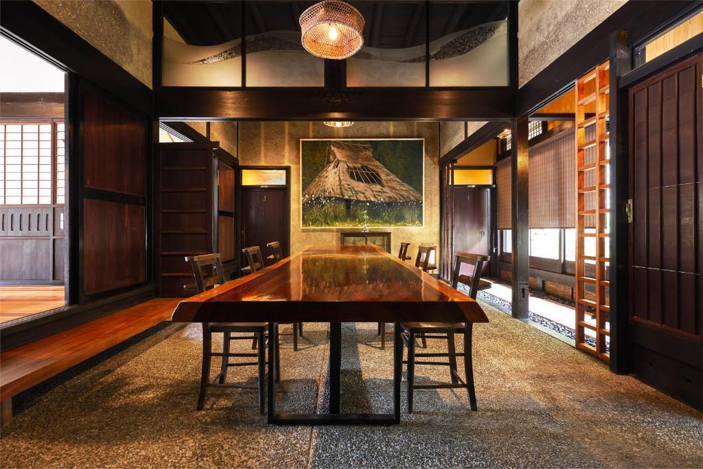 a dining room with a large wooden table and chairs at 京都ミヤマシキテイ in Nantan city