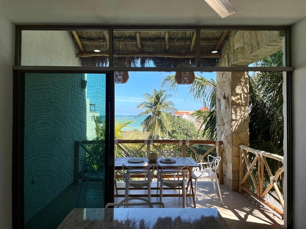 a dining room with a table and chairs on a balcony at Departamento El Cardumen in Chicxulub