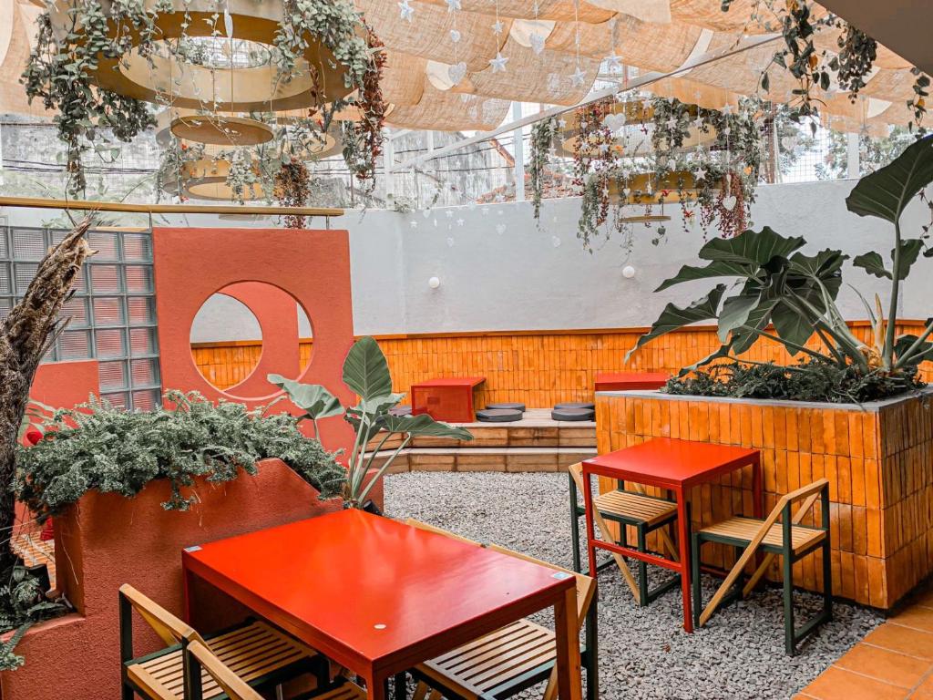 a patio with tables and chairs and plants at Mr A Hotel in Bandung