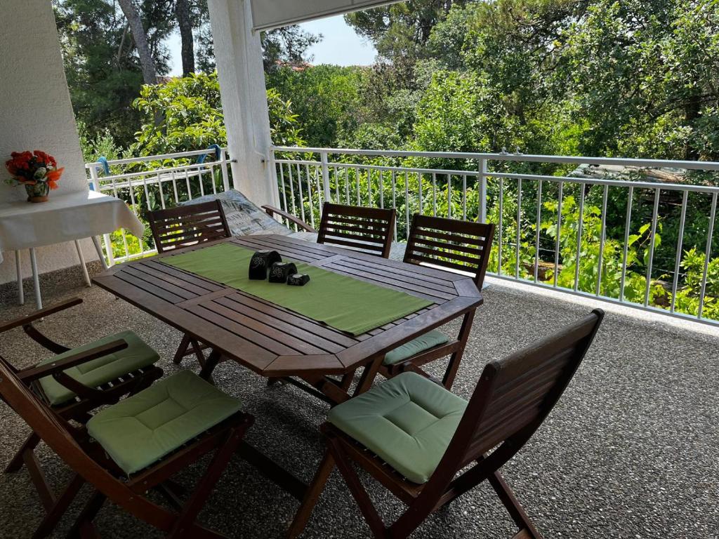 - une table et des chaises en bois sur une terrasse couverte dans l'établissement Apartment Juric NeVi, à Malinska