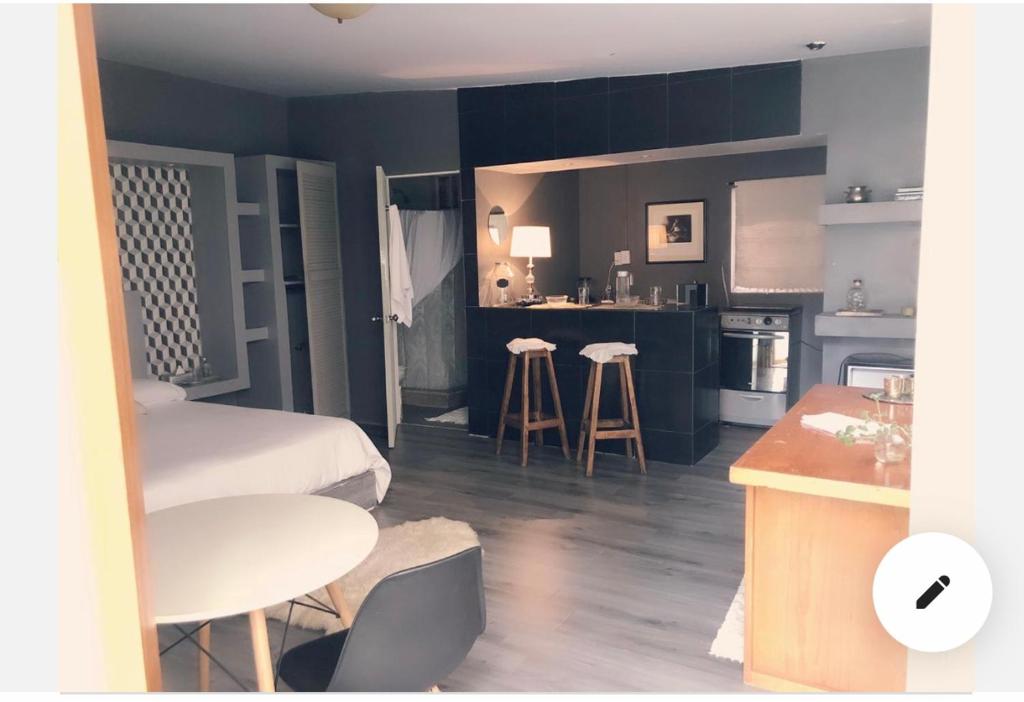 um quarto com uma cozinha com uma cama e uma mesa em Suite Privada en San Ángel em Cidade do México