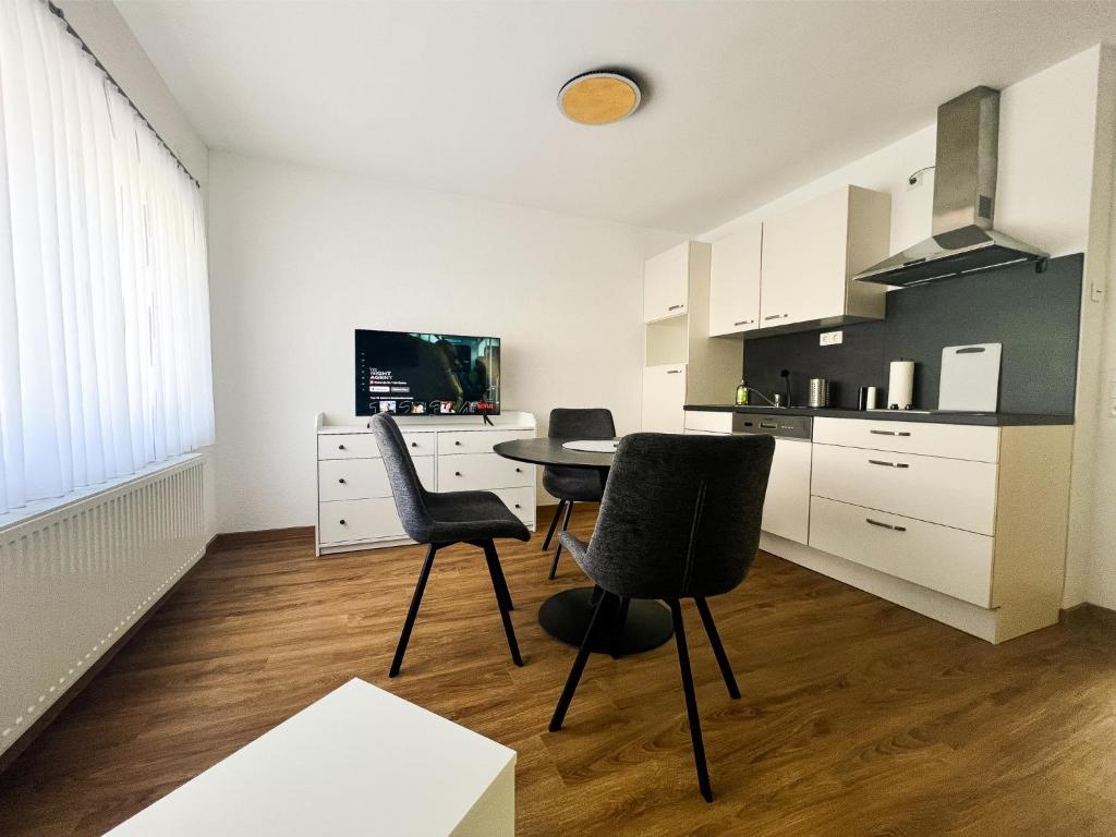 eine Küche mit einem Tisch und 2 Stühlen in einem Zimmer in der Unterkunft Modern Apartment Wissenbach 2 in Eschenburg
