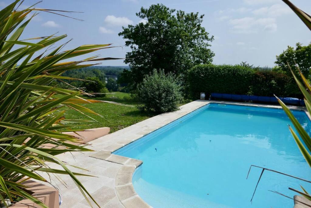 une grande piscine bleue dans une cour dans l'établissement Villa du tertre, à Fronsac