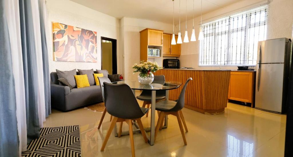 a kitchen and living room with a table and chairs at Villa Agata Mauritius in Mont Choisy