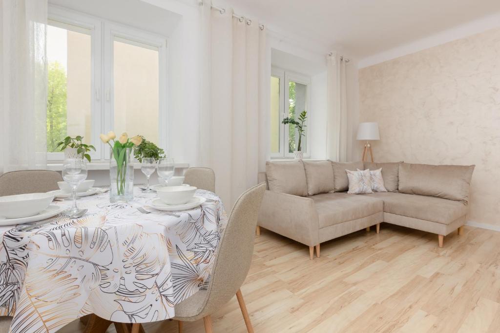 sala de estar blanca con mesa y sofá en Bright Apartment Wola near Metro Station by Renters, en Varsovia