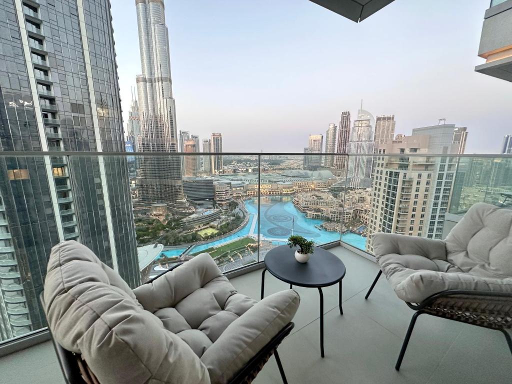 balcón con sillas y vistas a la ciudad en Luxurious 3 Bedroom Apartment with Burj Khalifa & Fountain View by Luxstay Holiday Homes, en Dubái