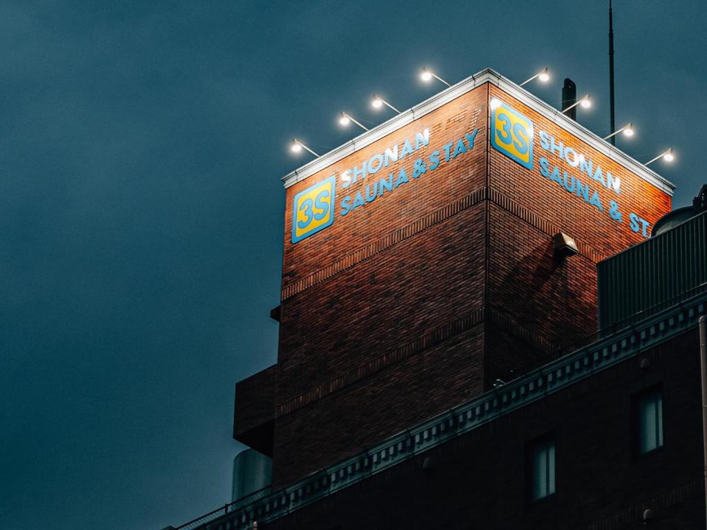 a sign on the side of a brick building at 3s HOTEL HIRATSUKA in Hiratsuka