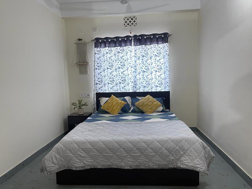 a bedroom with a bed with a blue curtain at Maria's Homestay in Siliguri