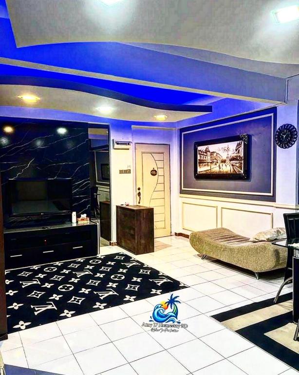 ein Wohnzimmer mit blauer Decke und einem TV in der Unterkunft Amy D’ Homestay Jacuzzi PD in Port Dickson