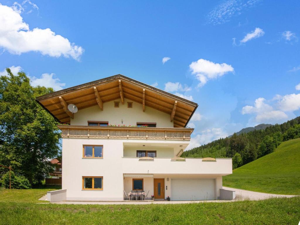 a house in the middle of a green field at Beautiful apartment in Hart im Zillertal with mountain view in Hart im Zillertal