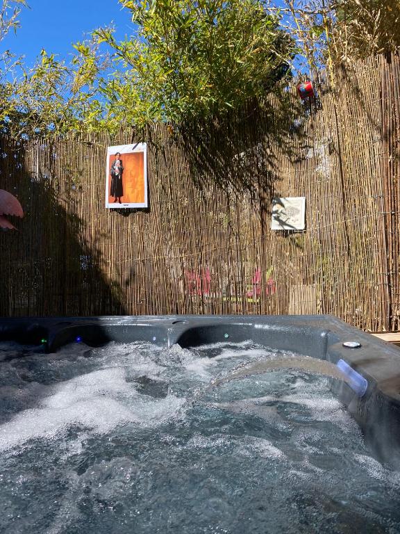 un bain à remous avec de la neige devant une clôture dans l'établissement La Paillère chambres d hôtes, à Mus