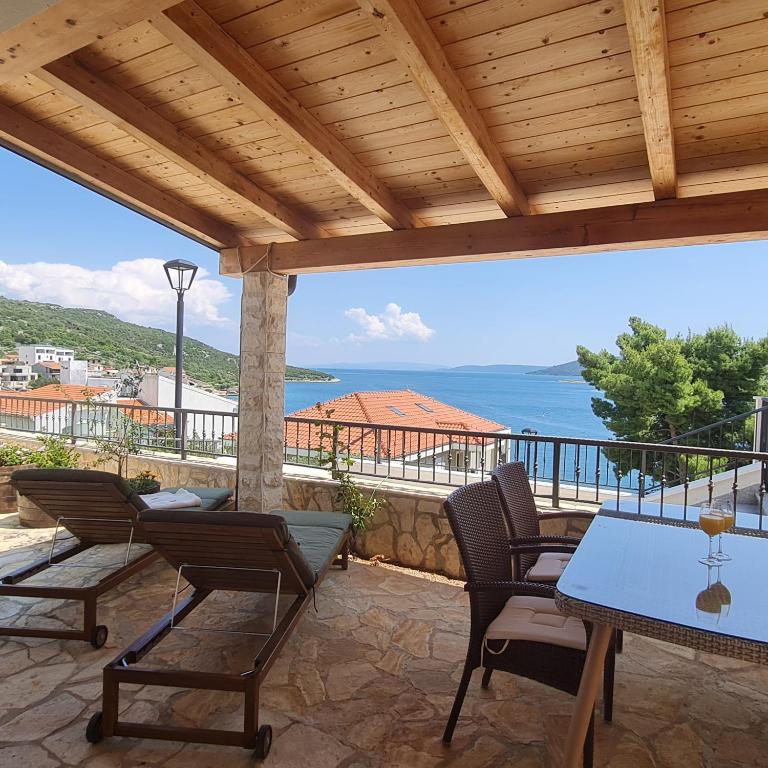 a patio with a table and chairs and the ocean at The View in Vinišće
