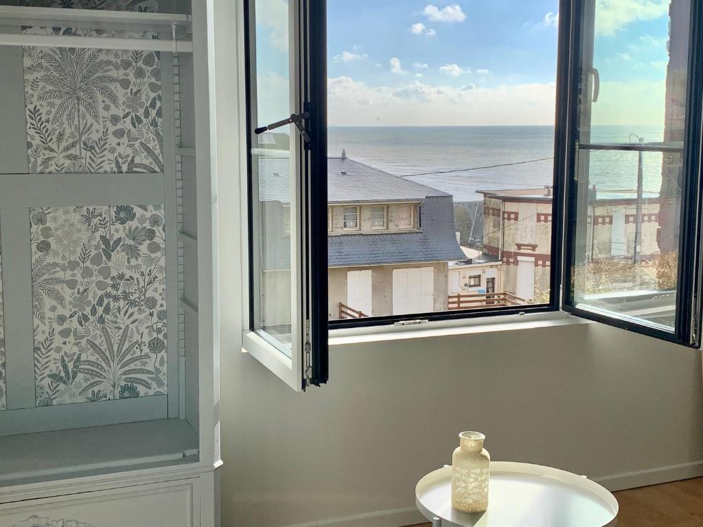 Cette chambre dispose d'une fenêtre offrant une vue sur l'océan. dans l'établissement LE NID SUR LA FALAISE, à Ault