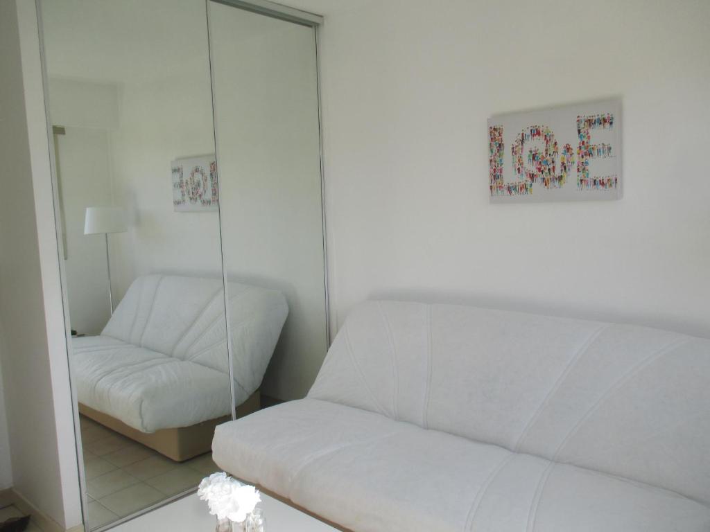 - un salon avec un canapé blanc et un miroir dans l'établissement Studio au calme à 5mn de la mer et de toutes attractions de la ville, à Cannes