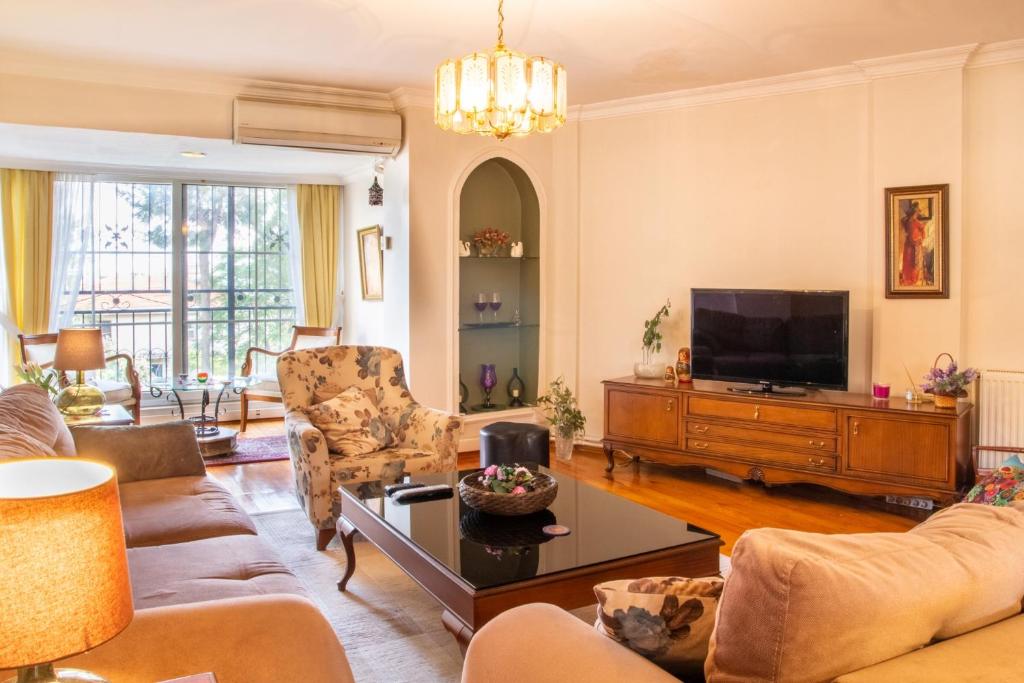 uma sala de estar com um sofá e uma televisão em Spacious Detached House with Garden in Izmir em Ulucak