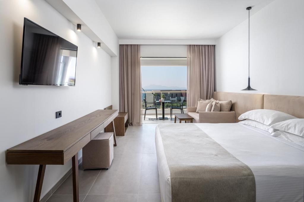 a hotel room with a bed and a television at Michelangelo Resort & Spa in Ágios Fokás