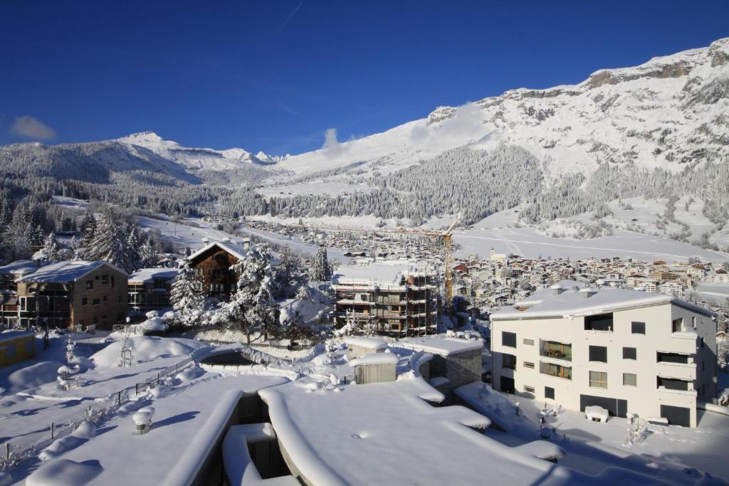 a city covered in snow with a mountain in the background at Edelweiss La Cerise in Flims