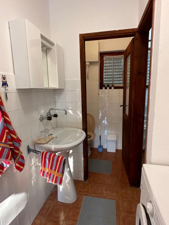 a bathroom with a white sink and a toilet at Holiday house“Tonka” in Žuljana