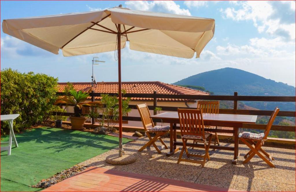 een tafel en stoelen met een parasol op een patio bij La Loggia di Vanda - Goelba in Rio nell Elba