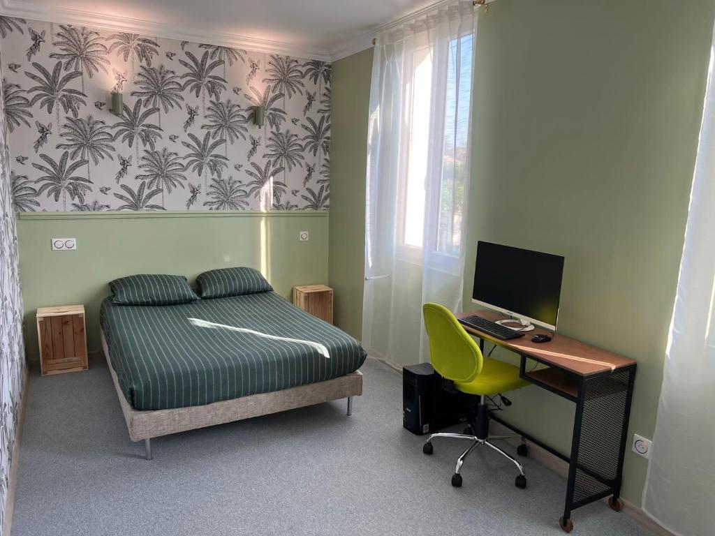 een slaapkamer met een bed, een bureau en een computer bij Maison au bord de l'eau et au calme pour les vacances in Saint-Denis-de-Pile
