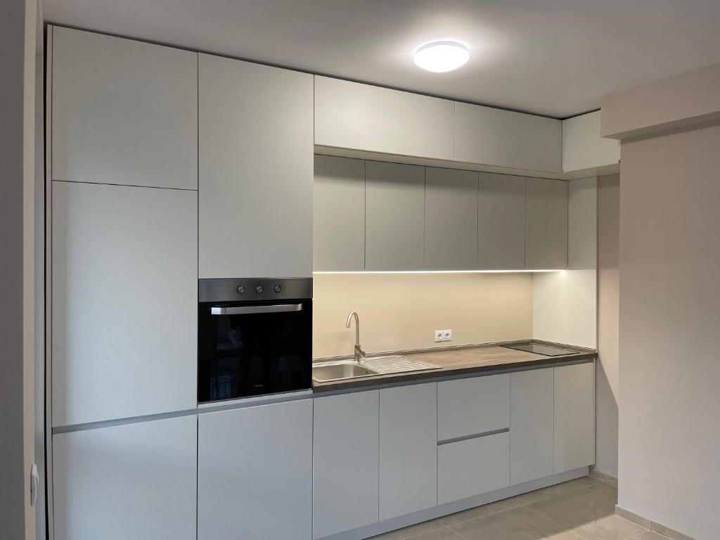 una cocina con armarios blancos y fregadero en Apartment Mladost 2 - Free Parking, en Sofía