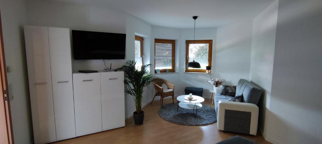 a living room with a tv on top of a white cabinet at FeWo Lindlar, Monteurwohnung in Lindlar