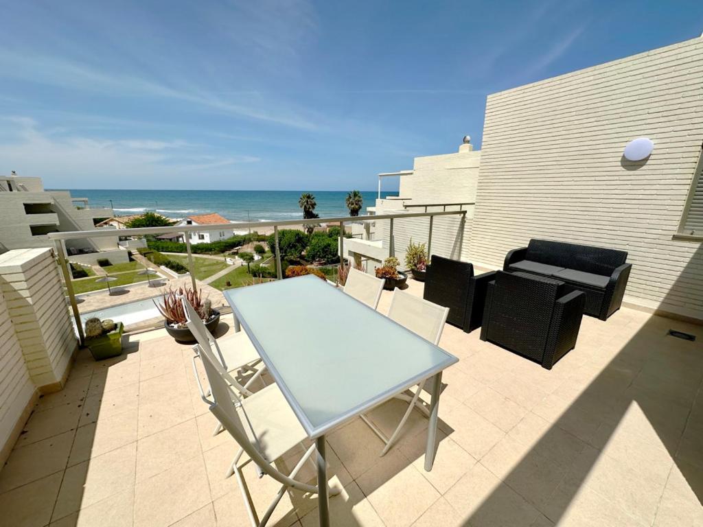 une terrasse avec une table et des chaises et l'océan dans l'établissement Tierra de Mar 05, à Dénia
