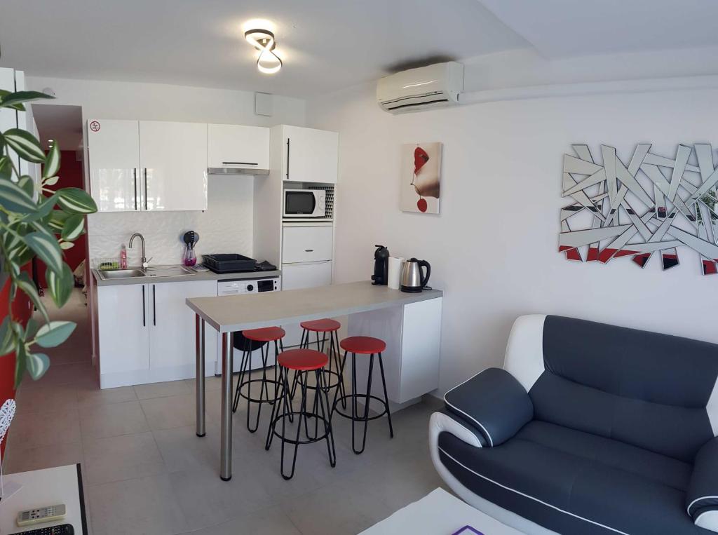- une cuisine et un salon avec une table et des tabourets dans l'établissement Cap d'Agde Port Nature, au Cap d'Agde