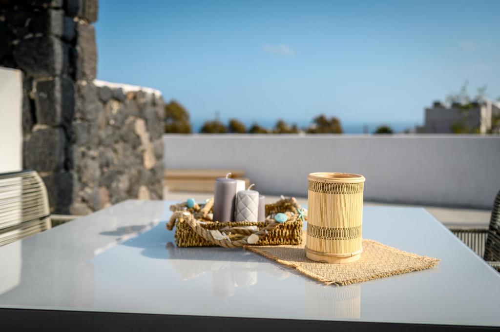 a table with a basket of candles on it at Sunset View Luxury Villas in Megalochori