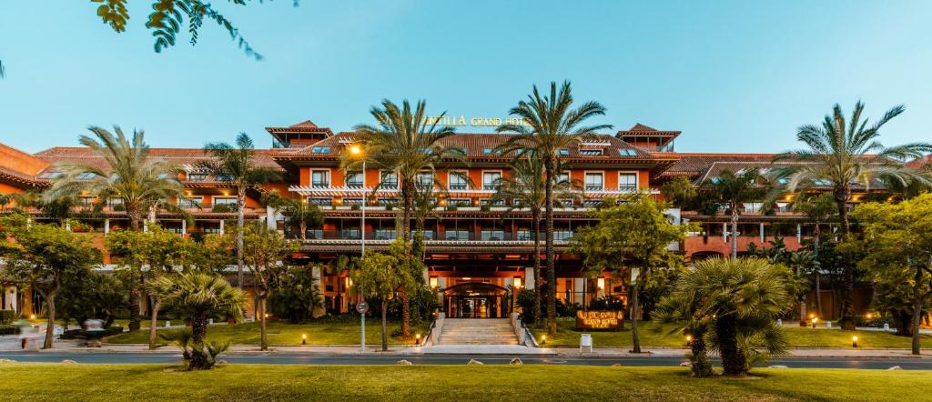 a large building with palm trees in front of it at Puerto Antilla Grand Hotel in Islantilla