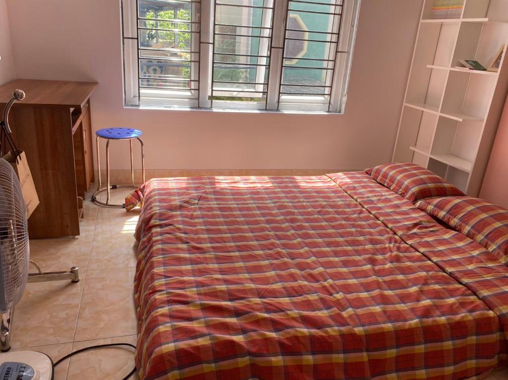a bedroom with a bed with a blanket on it at GM Homestay in Hai Phong