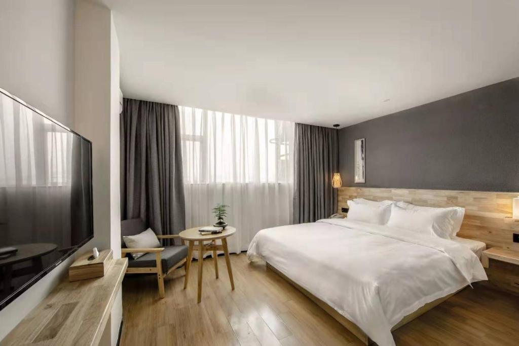 Postel nebo postele na pokoji v ubytování Guangzhou Shug Art Hotel