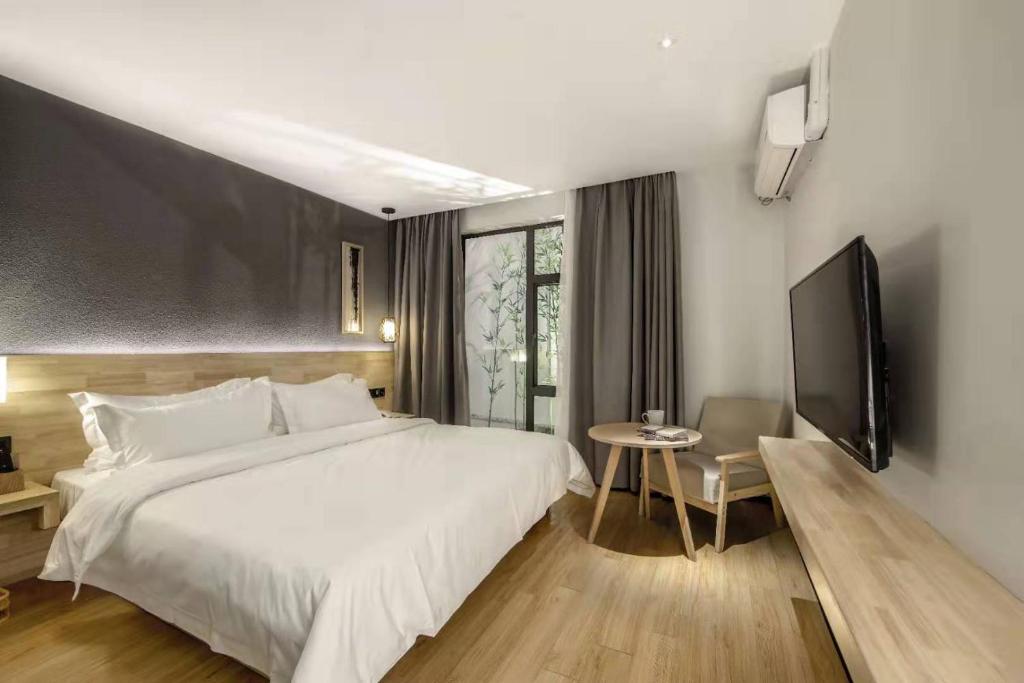 Postel nebo postele na pokoji v ubytování Guangzhou Shug Art Hotel