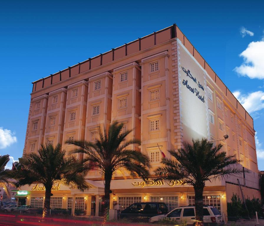 un gran edificio con palmeras delante en Ascot Hotel, en Dubái