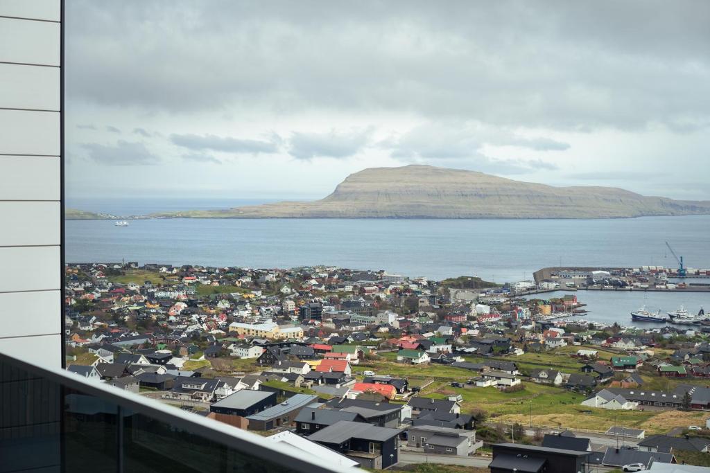 a view of a town with a mountain in the background at Nordic Swan Aparthotel with Panoramic Seaview in Tórshavn