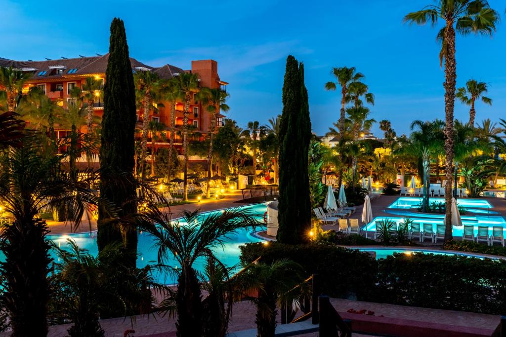 a view of the resort pool at night at Puerto Antilla Grand Hotel in Islantilla