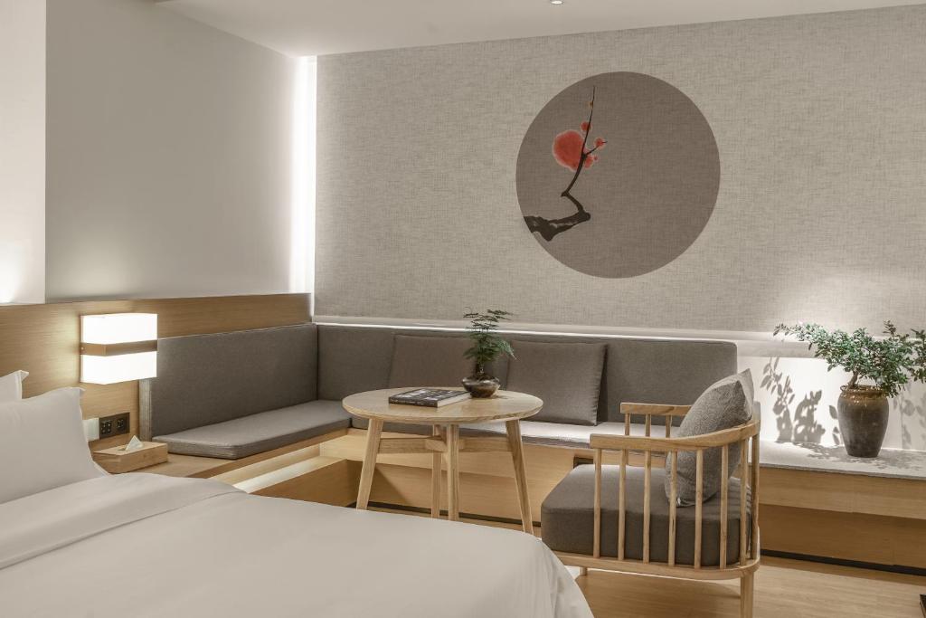 Postel nebo postele na pokoji v ubytování Guangzhou Shug Art Hotel