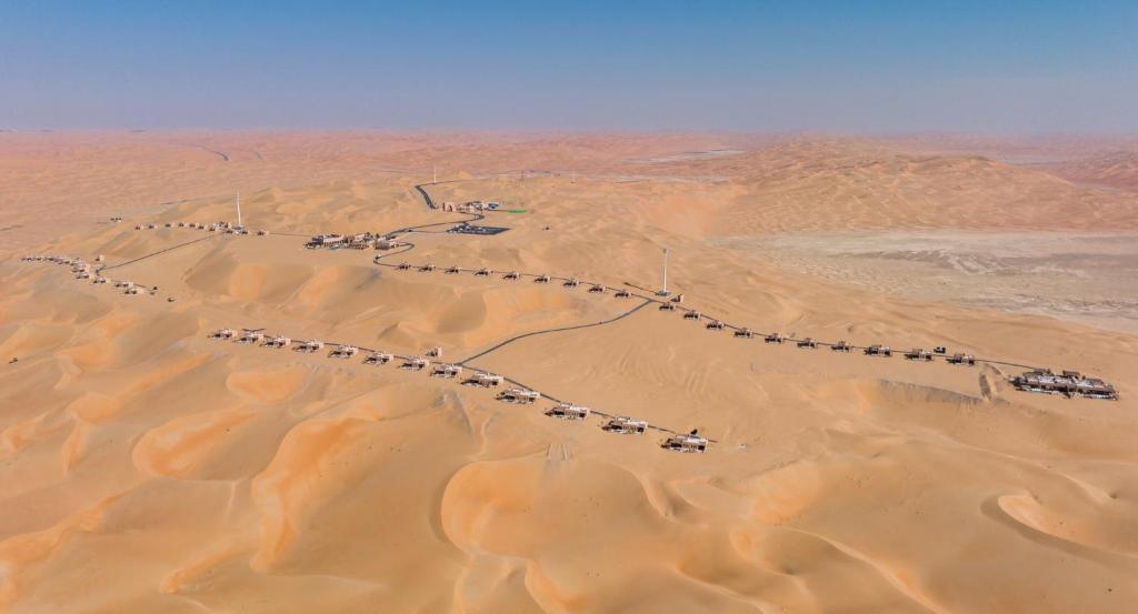 Bab Al Nojoum Bateen Liwa في ليوا: اطلالة جوية على صحراء مع طريق في الرمال