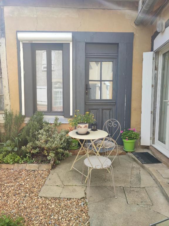 d'une terrasse avec une table et des chaises devant une porte. dans l'établissement Chambre d hote, à Bonnétable