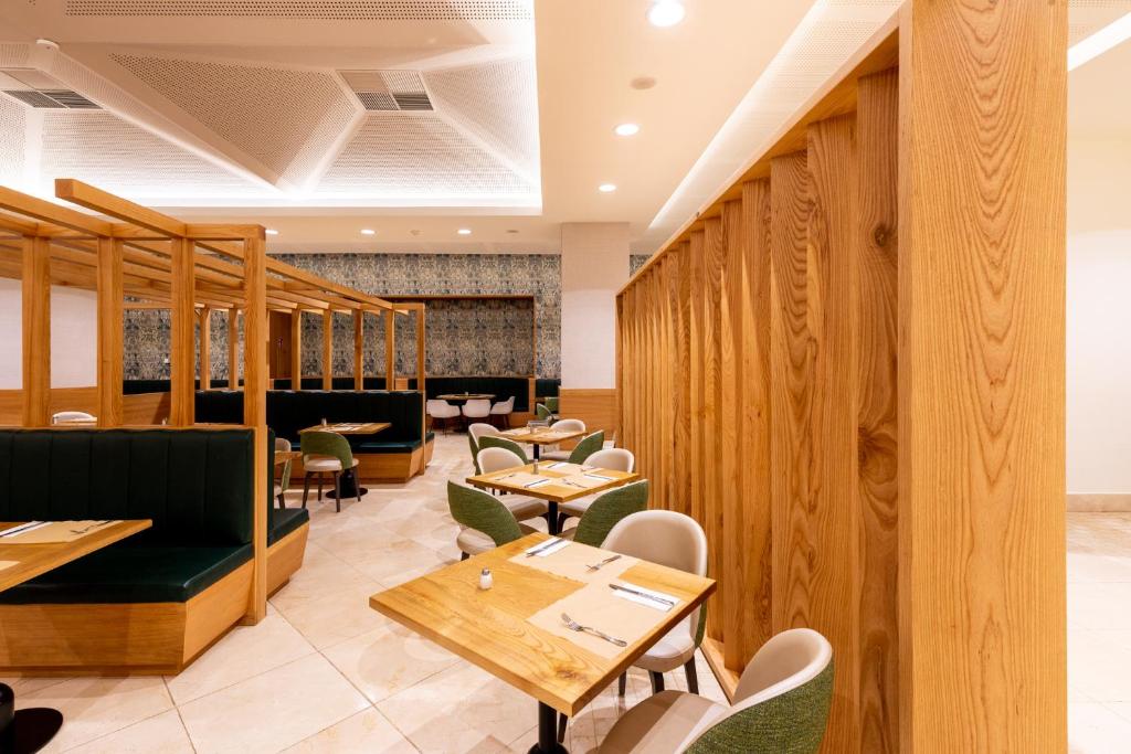 a restaurant with wooden walls and tables and chairs at Puerto Antilla Grand Hotel in Islantilla