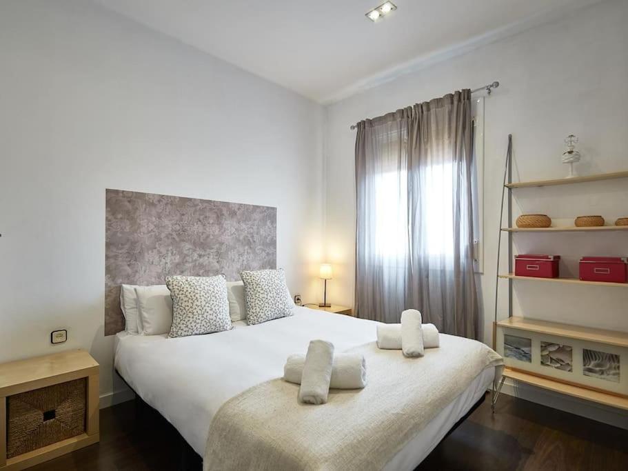 sypialnia z dużym łóżkiem z dwoma ręcznikami w obiekcie Bed&BCN Arquimedes Barcelona w Barcelonie
