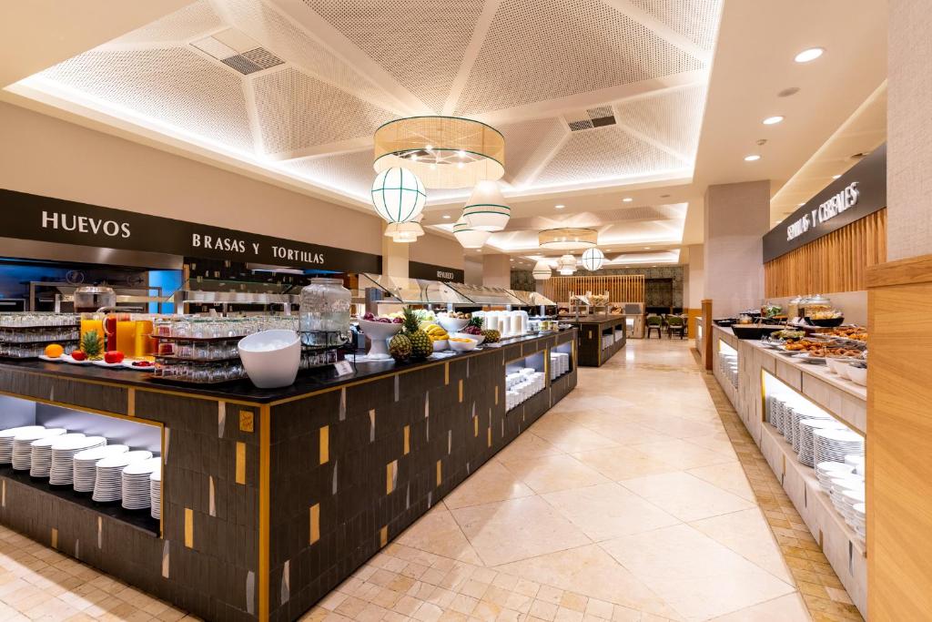 a restaurant with a buffet line with food at Puerto Antilla Grand Hotel in Islantilla