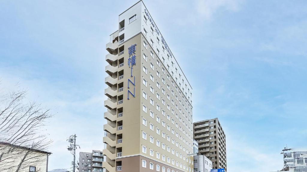 wysoki budynek z znakiem na boku w obiekcie Toyoko Inn Nagano-eki Higashi-guchi w mieście Nagano