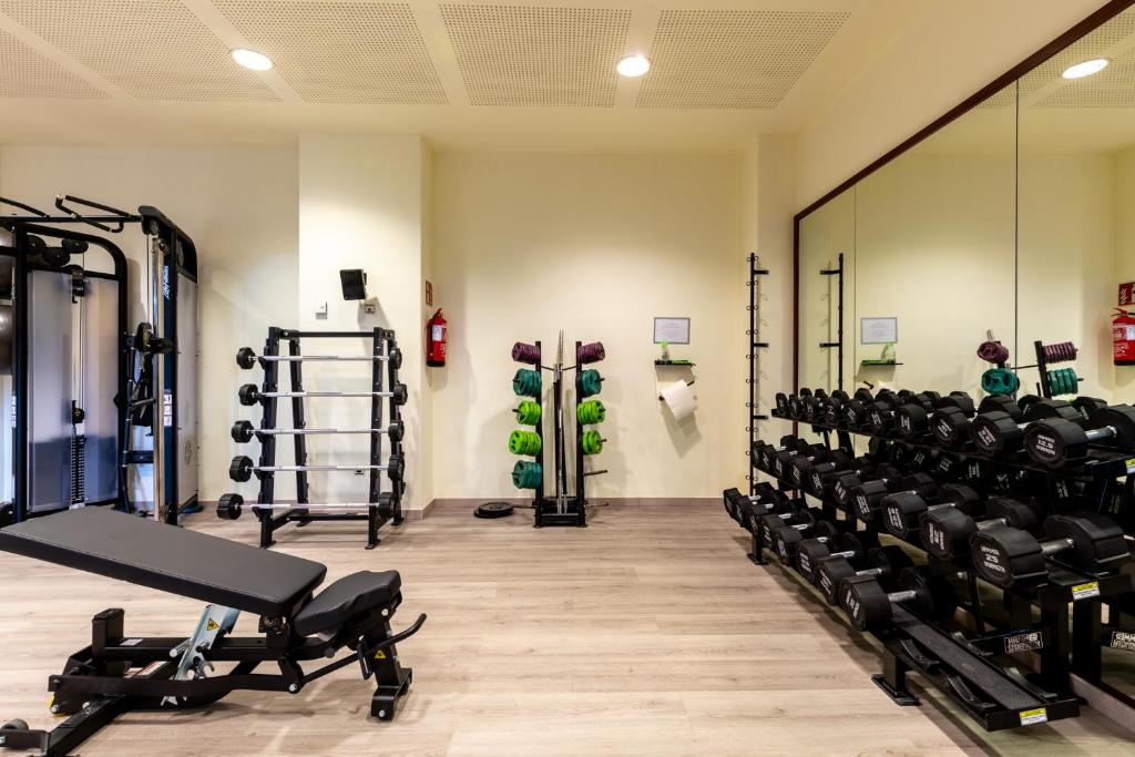 a gym with dumbbells and weights at Puerto Antilla Grand Hotel in Islantilla