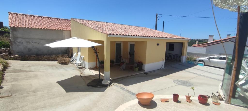 ein kleines Haus mit Sonnenschirm und Terrasse in der Unterkunft Festina Lente restful BNB with private pool and a car available in Carrascal