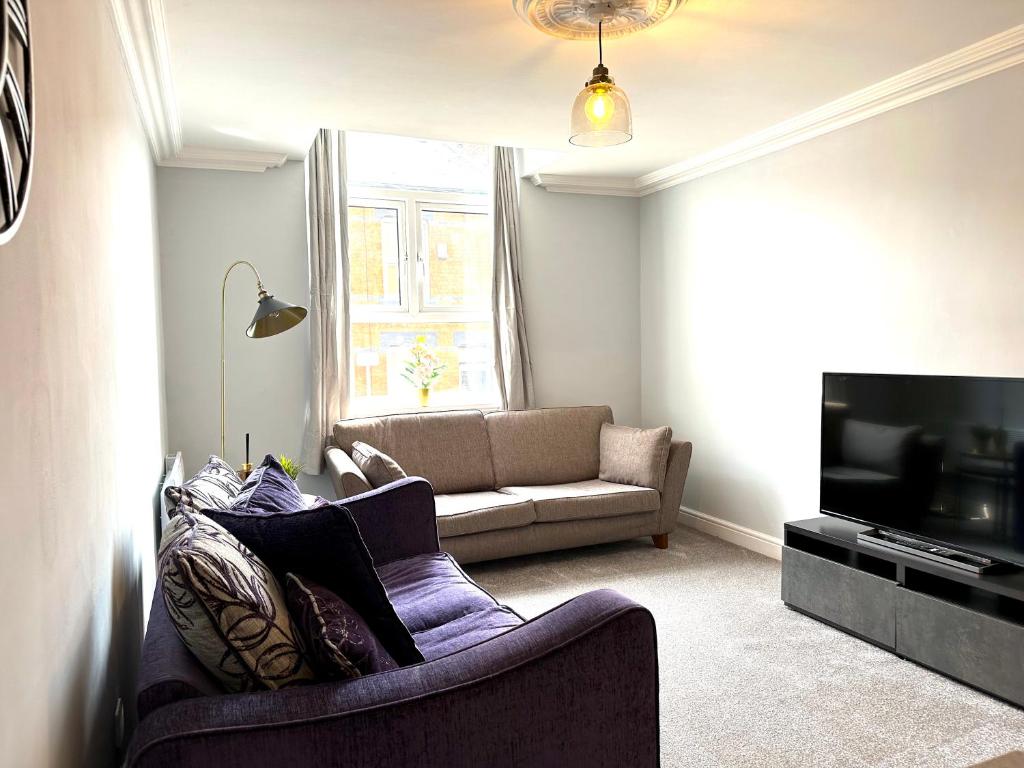 a living room with a couch and a tv at Comfortable City Apartment in Derby