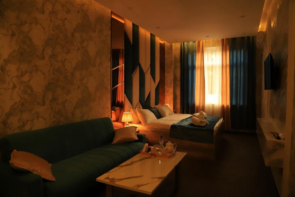 杜尚别Green Hotel Dushanbe的客厅配有绿色沙发和床。