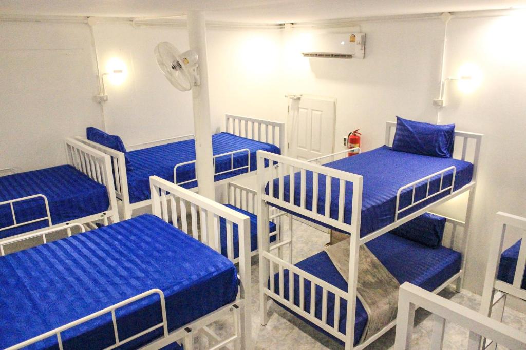 Pokój z 4 łóżkami piętrowymi i wentylatorem w obiekcie World Citizen Hostel w mieście Baan Tai