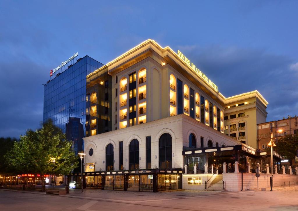 a large building in a city at night at Swiss Diamond Hotel Prishtina in Pristina