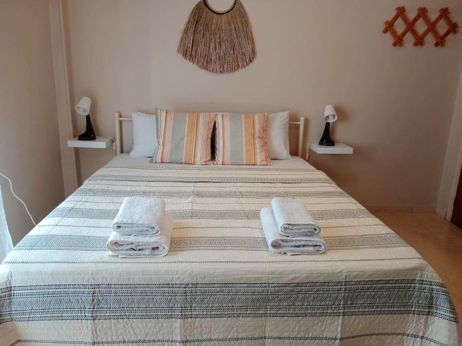 a bedroom with a bed with towels on it at Cherry - HappyHostGr - Downtown Apartment in Volos